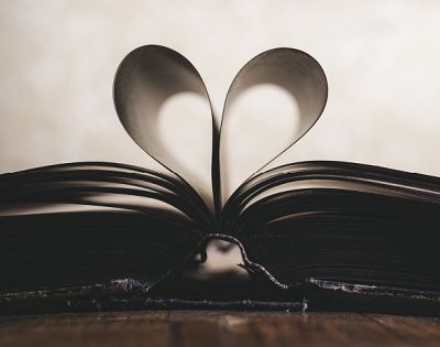 Knjiga z odprtimi stranmi, ki so upognjene v obliko srca.